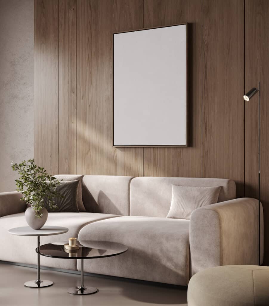 Salon moderne avec canapé beige incurvé, mur en bois clair et foncé, tableau blanc vierge, et lampe sur pied noire.